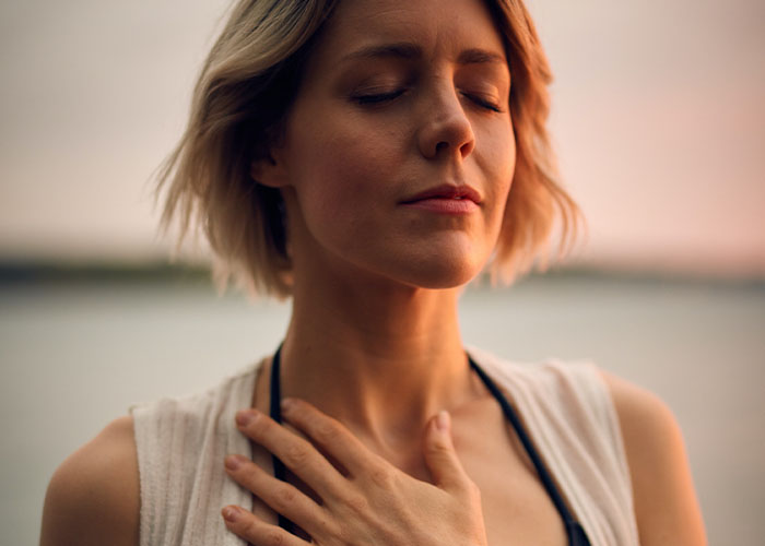 Woman breathing deeply with her hand on her chest